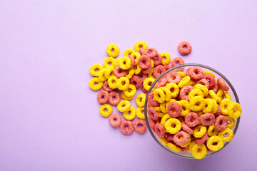 Fototapeta na wymiar Multicolor cereals with fruity on purple background. Blank space for texts.