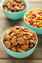 Variety of cereals in blue bowls, quick breakfast on grey wooden background. Vertical photo