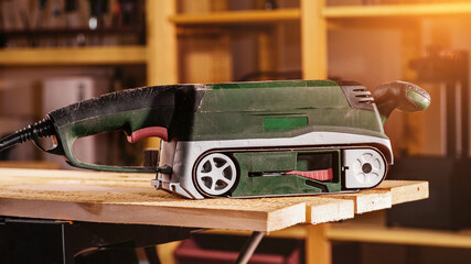 Obraz na płótnie Canvas an electric sander stands on a workbench in a workshop