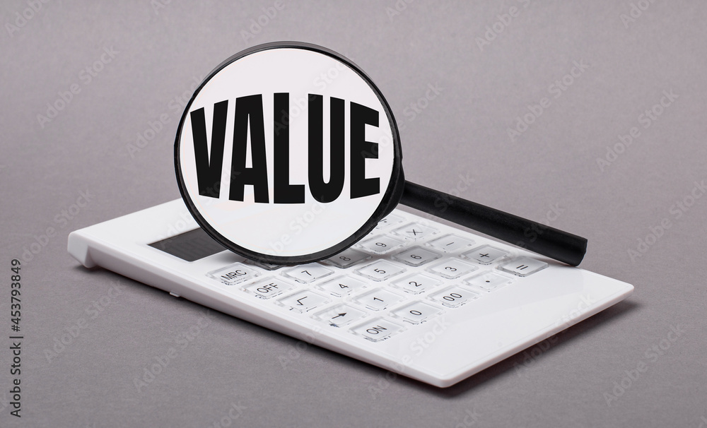 Poster on gray background black calculator and magnifier with text value. business concept