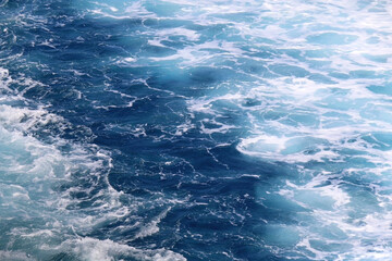 Fototapeta na wymiar Sea foam and deep blue sea. Selective focus.