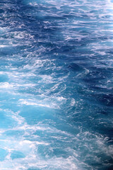Fototapeta na wymiar Sea foam and deep blue sea. Selective focus.