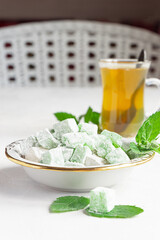 Turkish delight lokum on a plate with a glass of tea