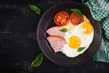 Fried eggs with ham and tomatoes. Delicious English Breakfast. Brunch. Keto, paleo diet. Top view, overhead