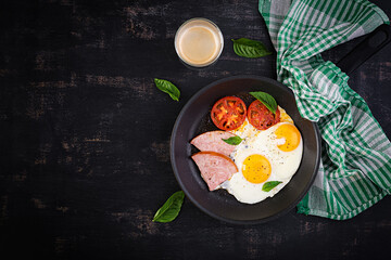 Fried eggs with ham and tomatoes. Delicious English Breakfast. Brunch. Keto, paleo diet. Top view, overhead