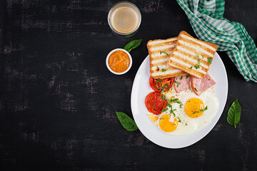 Fried eggs with ham, tomatoes and toasts. Delicious English Breakfast. Brunch. Top view, overhead