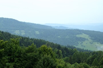 Fototapeta na wymiar Beautiful mountains scenery, green forest landscape during cloudy and foggy weather in mountains of Beskid in Poland.