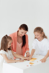 Obraz na płótnie Canvas Young teacher and preschool children learn the English alphabet using cards, blocks and toys 