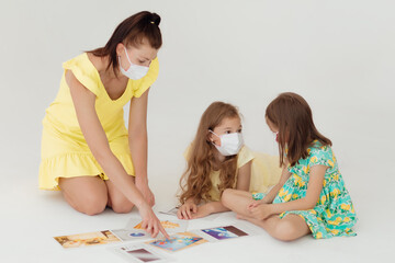 Language and foreign language learning. An English teacher conducts a masked lesson to two masked...