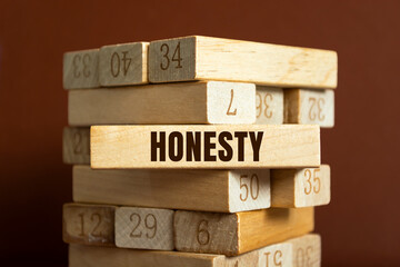 Modern business buzzword - honesty. Word on wooden blocks on a brown background. Close up.