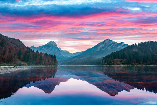 Peaceful autumn view on Obersee lake in Swiss Alps. Dramatic sunset sky and mountains reflections in clear water. Nafels village, Switzerland. Landscape photography