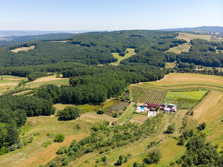 Fototapeta na wymiar Aerial view of remote house with swimming pool, lake and orchard. Summer 2021