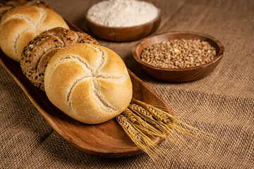 Freshly baked warm buns placed on a wooden bowl.