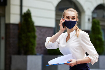 business woman in medical mask talking on phone