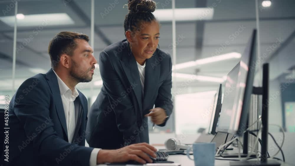 Poster senior manager talking to young confident businessman while using computer in modern office. colleag