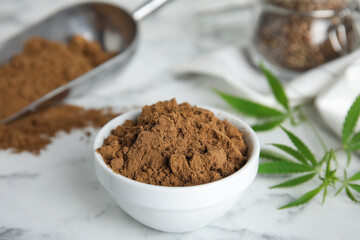 Hemp protein powder and fresh leaves on white marble table, closeup