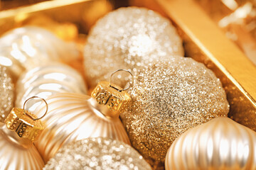 Merry Christmas and Happy New Year. Box of rich golden and crystal festive ornaments baubles tinsel stars glitter and Party decor. Full frame close up. Monochrome. Side view