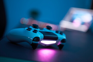 Gaming controller laying on table. Close-up of controller in low light room. Selective focus.