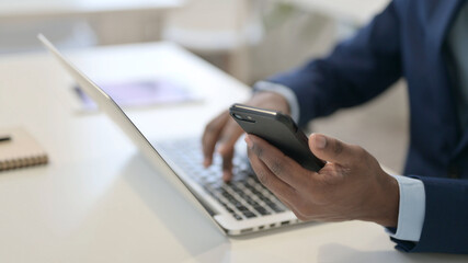 African Businessman using Laptop and Smartphone, Close up