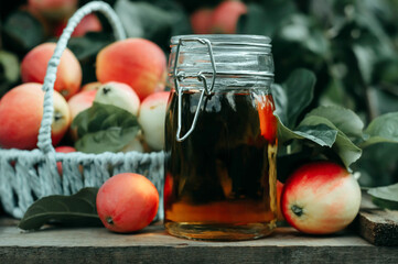 apple cider vinegar in a glass bottle with natural apples