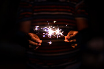 Boy hand hold with showing the sparklers in night time of celebration.