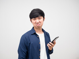 Asian man holding cell phone in hand with bored face and not not satisfied white background