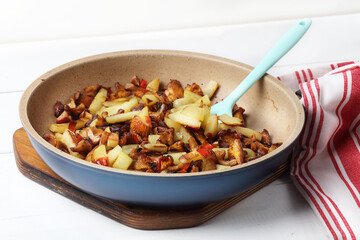 Homemade fried potatoes with chanterelles, garlic and chili pepper