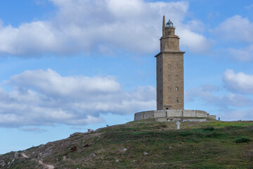 Fototapeta na wymiar La Coruna, Spain 11-08-2018. Hercules Tower surrounded by big clouds on a beautiful day. A roman lighthouse still in use today. Unesco World Heritage