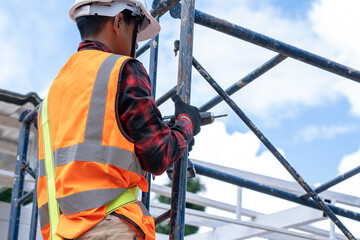 Construction workers wearing safety harness working at high level in the construction site,Roofing...