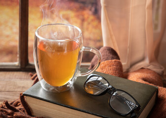 Hot mug of tea with autumn background