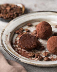 Chocolate candies. Delicious dessert on a light background. Coffee truffles. Sweets on a white plate. Macro photography of sweets. Candy Cut.