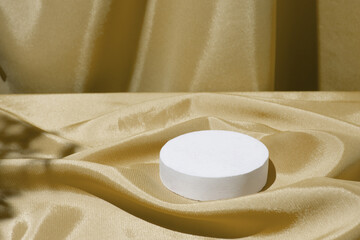 Satin fabric folds and podium or pedestal for cosmetics or perfume