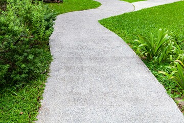Long concrete walkway in the summer green garden