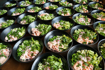 Shrimp salad bowls lined up at a conference for lunch guests.