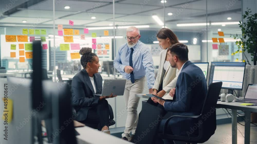 Aufkleber in modern office: diverse team of managers use laptop and tablet computers at a company meeting disc