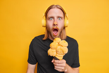 Emotional guy with red long hair stares shocked finds out horible news eats sweet summer dessert...