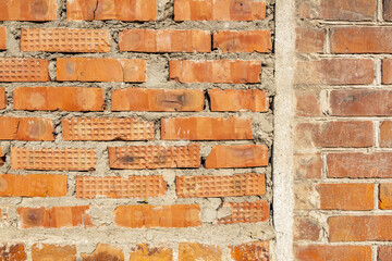 Embossed textured surface of an old wall made of facade bricks and cement