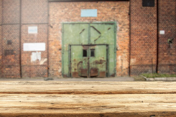 A wooden table surrounded by old factories with a free space 