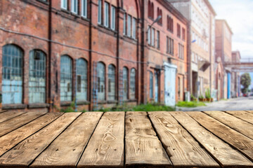 Fototapeta na wymiar A wooden table surrounded by old factories with a free space 