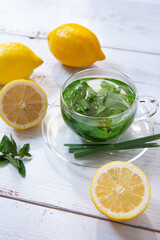 herbal tea with lemons on white wooden background