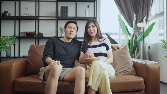 asian adult lover marry couple enjoy  watching tv on sofa couch together with peaceful and happiness at home,home quarantine isolation lifetyle