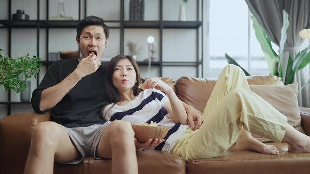 asian adult lover marry couple enjoy  watching tv on sofa couch together with peaceful and happiness at home,home quarantine isolation lifetyle