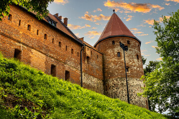 Defense walls and tower of medieval gothic Bytow Castle of Teutonic Order and Pomeranian Dukes in historic city center in Poland - obrazy, fototapety, plakaty
