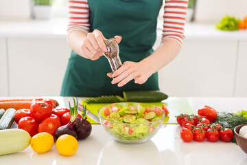 Photo of housewife hands dressed green apron cooking tasty diet supper adding black pepper indoors...
