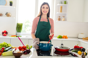 Photo of happy cheerful pretty young woman wear glove cook dinner soup pan indoors inside house kitchen