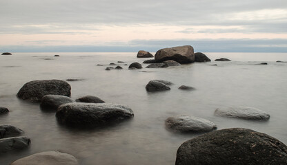 Fototapeta na wymiar Seaside with big stones, long exposure photo.