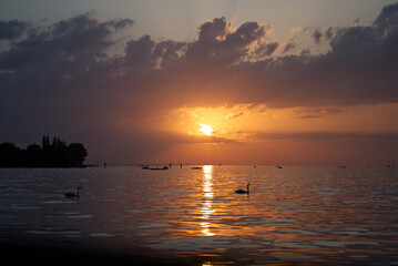 Beautiful sunset on a summer evening seen from border of lake Bodensee at City of Bregenz. Photo taken August 15th, 2021, Bregenz, Austria. 