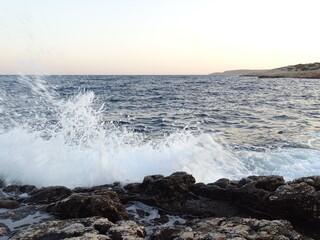 waves crashing on rocks during sunset  in mediterranean August 29  2021 