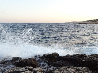 waves crashing on rocks during sunset  in mediterranean August 29  2021 