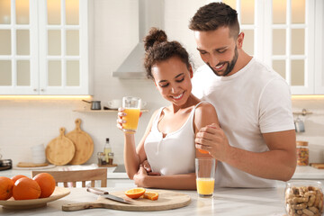 Lovely couple enjoying time together during breakfast at table in kitchen